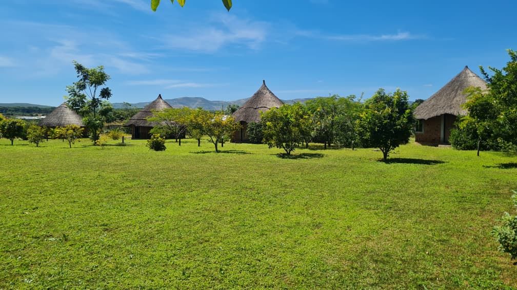Thatched chalets spread across the lawn at Kigelia, with the Chipata hills behind